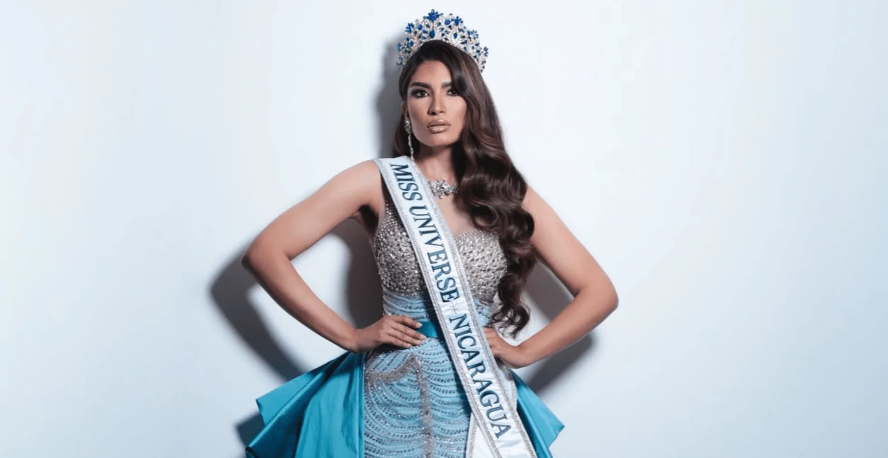 Geyssell García, Miss Universe Nicaragua 2024, con corona y banda, manos en la cintura